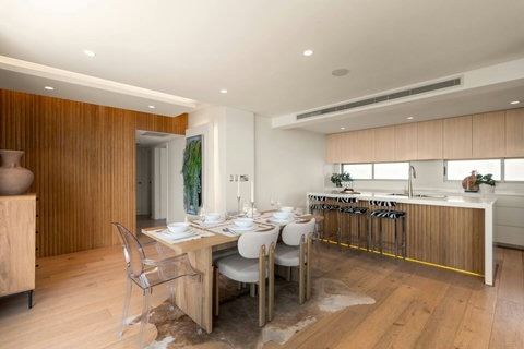 Dining for six beside the kitchen, with timber finishes and an easy flow through the main living space