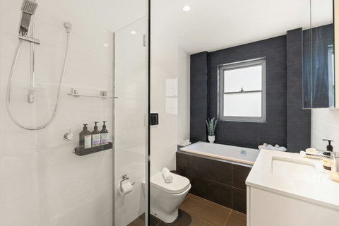 Bright bathroom with a separate walk-in shower, bathtub and practical storage