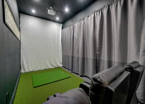 Ultimate Entertainment Hub: Experience a combined Golf Studio, Game & Movie room with cozy bean bag chairs for a perfect movie or game night.
