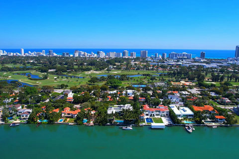 A breathtaking aerial view of Miami Beach Golf Club, shimmering Intracoastal Waterways and sparkling beach life. Ultimate coastal lifestyle, luxury boat charters, championship golf, pickleball, world-class dining, upscale shopping, vibrant nightlife.