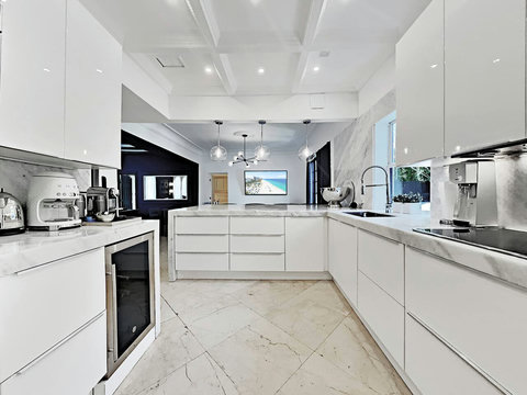 Entertaining Perfect Private Chef Dining Kitchen with Brazilian marble waterfall kitchen bar. Stainless build-in custom appliances with state of art induction cooking and wine fridge, soda stream, and nespresso cappucino maker.  