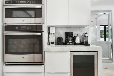 Entertaining Perfect Private Chef Dining Kitchen with Brazilian marble waterfall kitchen bar. Stainless build-in custom appliances with state of art induction cooking and wine fridge, soda stream, and nespresso cappucino maker.  