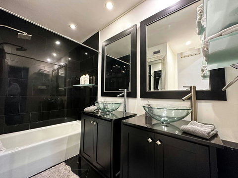 Step into this contemporary bathroom with dual sinks and a shower and bathtub combination. 
