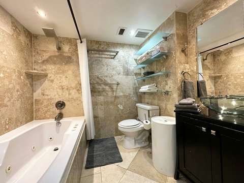 Unwind in style with both a shower and a jacuzzi tub in this elegant bathroom.