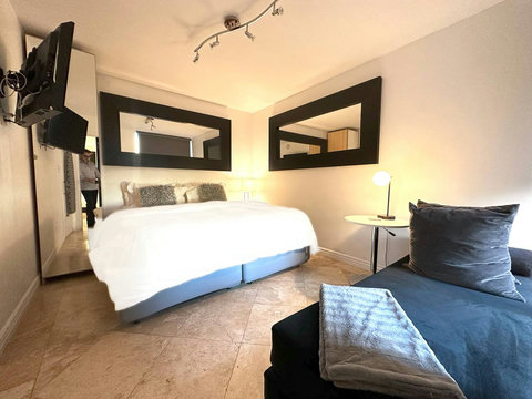 Bedroom with 1 King or 2 Twin Beds, 24-inch Smart TV, and closet. All Bedrooms come with comfortable down comforters and down pillows.
