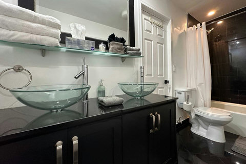 Modern bathroom with a combination shower - bathtub, and dual sinks.