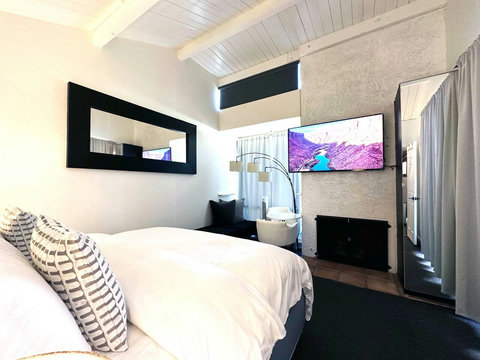 Luxurious Master Bedroom with Golf Course Views, Private Balcony, and 60-inch Smart TV. All Bedrooms come with comfortable down comforters and down pillows.
