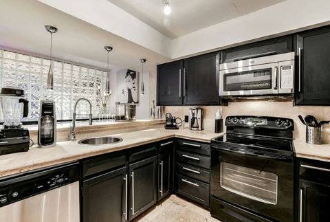 Sleek Modern Kitchen with Dine-in Bar & Stainless Steel Appliances.