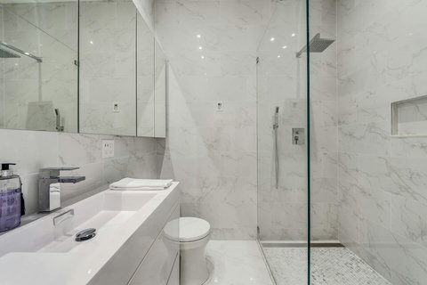 Indulge in comfort! Experience our elegant spacious bathroom with a modern shower, inviting you to unwind and refresh.