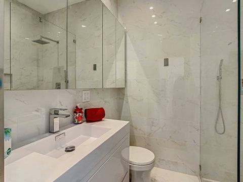 Indulge in comfort! Experience our elegant spacious bathroom with a modern shower, inviting you to unwind and refresh.