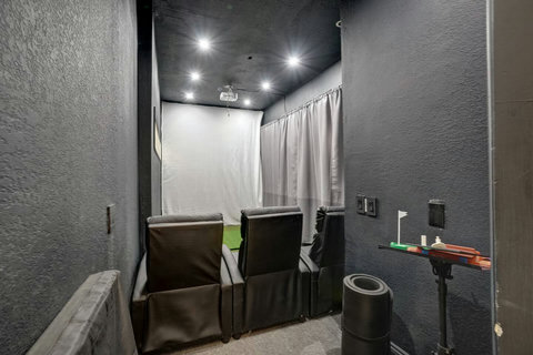 Ultimate Entertainment Hub: Experience a combined Golf Studio, Game & Movie room with cozy bean bag chairs for a perfect movie or game night.
