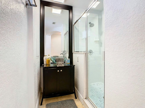 Pamper yourself in style! Unwind in this chic bathroom with a refreshing shower, offering a tranquil escape.
