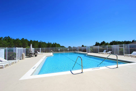 Relax in the Lap Pool at Disney Mansion's Resort - a serene oasis offering beautiful views of your private pool, championship golf course, and resort clubhouse with Lap Pool, Pickleball, Tennis, and Children's Playground amenities.
