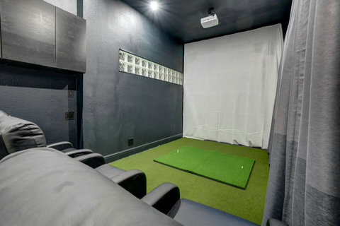 Ultimate Entertainment Hub: Experience a combined Golf Studio, Game & Movie room with cozy bean bag chairs for a perfect movie or game night.
