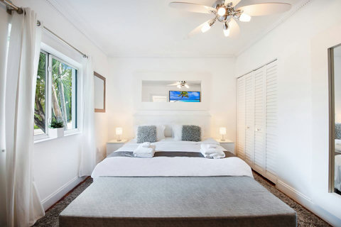 An elegantly designer bedroom boasting a luxurious KING-size beds (or 2 twin beds upon request), a sleek professional workspace, and closet, window that create a bright, open, and sophisticated atmosphere.
