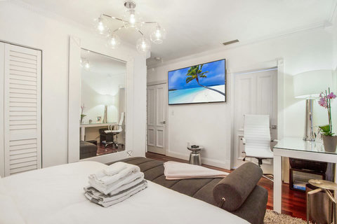 An elegantly designer bedroom boasting a luxurious KING-size beds (or 2 twin beds upon request), a sleek professional workspace, and closet, window that create a bright, open, and sophisticated atmosphere.