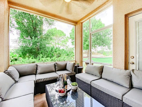 Relax and unwind in this stunning outdoor living room patio with a wall-mounted TV, offering picturesque views of the PGA Clubhouse and Learning Center.
