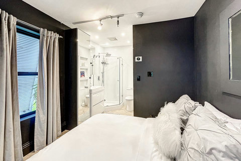 An elegantly compact designer bedroom boasting a luxurious KING-size beds (or 2 twin beds upon request), and closet, window and french doors leading out to balcony walkway which create a bright, open, and sophisticated atmosphere.