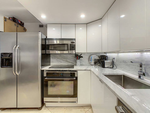 Fully equipped kitchen with stainless steel appliances, state-of-the-art induction cook-top, convection health cooking oven, built-in oven, Brazilian marble counter top, Nespresso cappuccino maker, Keurig coffee maker, brew coffee, and condiments. 