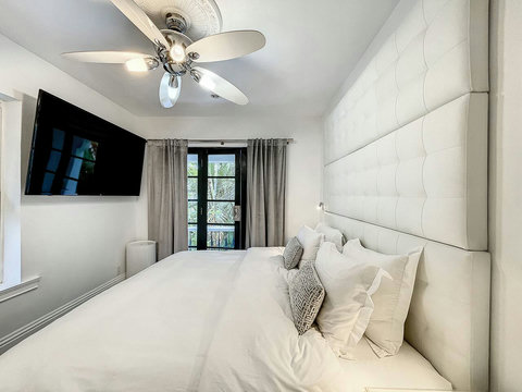 An elegantly compact designer bedroom boasting a luxurious KING-size beds (or 2 twin beds upon request), and closet, window and french doors leading out to balcony walkway which create a bright, open, and sophisticated atmosphere.