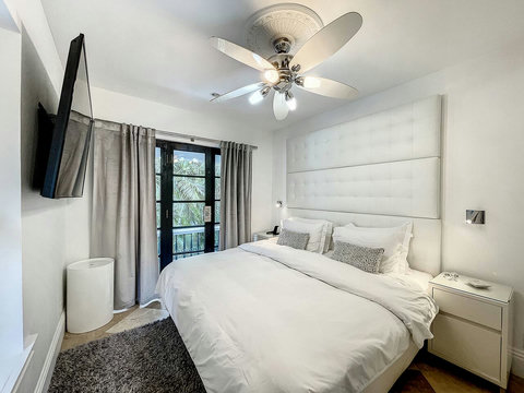 An elegantly compact designer bedroom boasting a luxurious KING-size beds (or 2 twin beds upon request), and closet, window and french doors leading out to balcony walkway which create a bright, open, and sophisticated atmosphere.