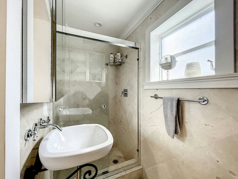 Bathroom, with toilet, sink and shower.