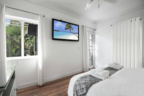 An elegantly designer bedroom boasting a luxurious KING-size beds (or 2 twin beds upon request), a sleek professional workspace, and closet, window that create a bright, open, and sophisticated atmosphere.