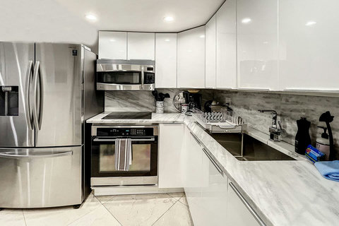 Fully equipped kitchen with stainless steel appliances, state-of-the-art induction cook-top, convection health cooking oven, built-in oven, Brazilian marble counter top, Nespresso cappuccino maker, Keurig coffee maker, brew coffee, and condiments. 