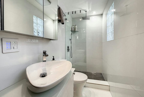 Bathroom, with toilet, sink and shower.
