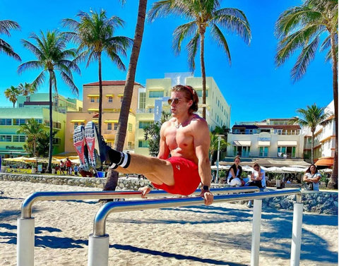 Welcome to our charming Casa Grande Suites building, adorned with Mediterranean-style clay tiles and cheerful yellow awnings, as seen in the background of this photo. The Beach Gym awaits right in front, courtesy of Muscle Beach South Beach.
