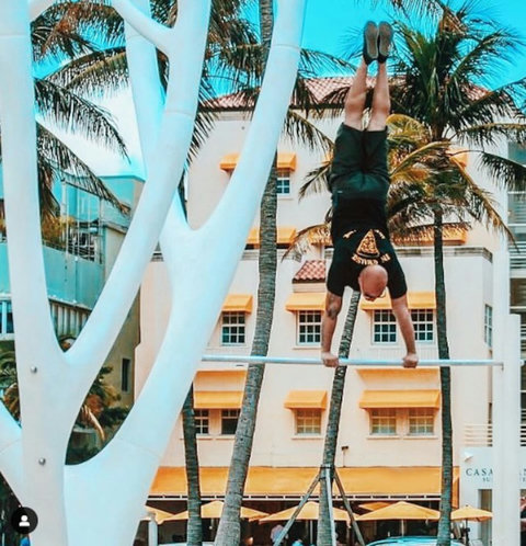 Welcome to our charming Casa Grande Suites building, adorned with Mediterranean-style clay tiles and cheerful yellow awnings, as seen in the background of this photo. The Beach Gym awaits right in front, courtesy of Muscle Beach South Beach.
