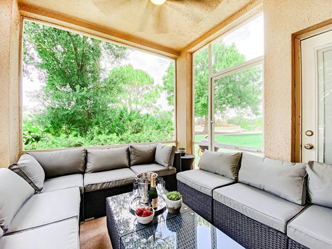 Relax and unwind in this stunning outdoor living room patio with a wall-mounted TV, offering picturesque views of the PGA Clubhouse and Learning Center.
