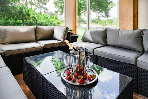 Relax and unwind in this stunning outdoor living room patio with a wall-mounted TV, offering picturesque views of the PGA Clubhouse and Learning Center.
