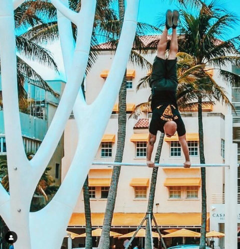 Welcome to our charming Casa Grande Suites building, adorned with Mediterranean-style clay tiles and cheerful yellow awnings, as seen in the background of this photo. The Beach Gym awaits right in front, courtesy of Muscle Beach South Beach.
