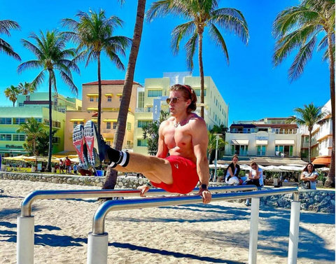 Welcome to our charming Casa Grande Suites building, adorned with Mediterranean-style clay tiles and cheerful yellow awnings, as seen in the background of this photo. The Beach Gym awaits right in front, courtesy of Muscle Beach South Beach.