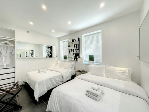Luxurious Bedroom Retreat - Indulge in comfort with a 70-inch Smart TV, memory foam mattresses, cozy dimmer lighting, USB chargers, and stylish designer mirrors.