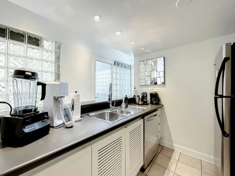 Modern full-size kitchen with a bar, equipped with Nespresso and Keurig coffee makers, a toaster, a Soda Stream for sparkling waters, and Vitamix for the perfect health drinks.