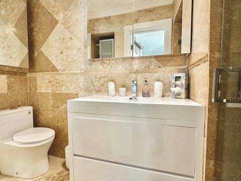 Bathroom, with toilet, sink and shower.