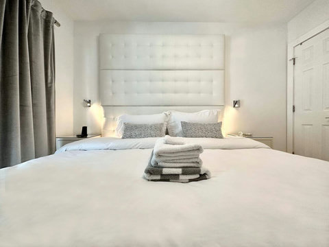 An elegantly compact designer bedroom boasting a luxurious KING-size beds (or 2 twin beds upon request), and closet, window and french doors leading out to balcony walkway which create a bright, open, and sophisticated atmosphere.