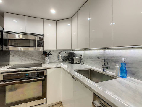 Fully equipped kitchen with stainless steel appliances, state-of-the-art induction cook-top, convection health cooking oven, built-in oven, Brazilian marble counter top, Nespresso cappuccino maker, Keurig coffee maker, brew coffee, and condiments. 