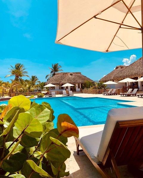 Club de playa privado con pago de consumo mínimo por persona para acceder.