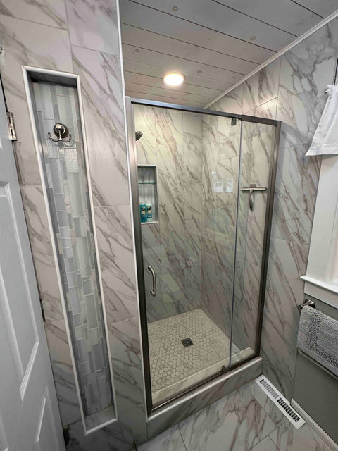 Enjoy a relaxing shower in the new, Kerdi-waterproofed enclosure featuring ceramic tile with niche, glass DreamLine door system, and Moen fixtures. The dimmable shower light is controlled independently from other bathroom lights.