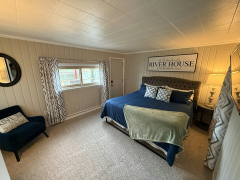 Master bedroom featuring Stainmaster carpet, paint, window treatments, closet with shelves & drawers, King memory foam bed with padded headboard, and chair/table. Master bedroom has Hisense Inverter Window Air Conditioner.