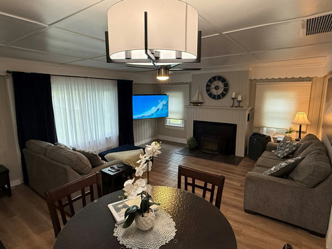 The freshly painted living room features a couch, loveseat, dining room table with high top chairs and expandable leaf. 

Enjoy the 58" 4K tv with 3.1 channel soundbar and wood burning fireplace insert.