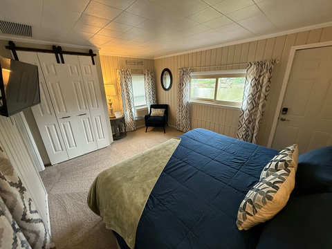 Master bedroom featuring Stainmaster carpet, paint, window treatments, closet with shelves & drawers, King memory foam bed with padded headboard, and chair/table. Master bedroom has Hisense Inverter Window Air Conditioner.