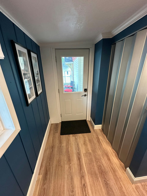 Secondary entrance with electronic keypad into the kitchen. Behind the silver retractable door are the washer and dryer.
