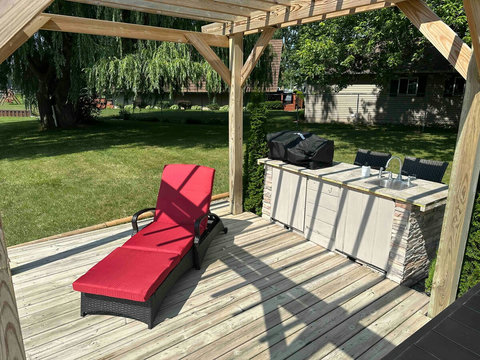 The patio features a wet bar with propane grill, sink, seating and storage.