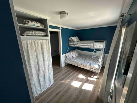 Guest/kids room with fresh paint and luxury vinyl tile flooring. Features a metal bunk bed with memory foam mattresses, linens and pillows - twin over full size beds.