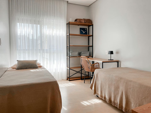 2 camas de solteiro, encostadas na parede. Neste formato o quarto ganha mais espaço de circulação e as paredes de segurança ao dormir.