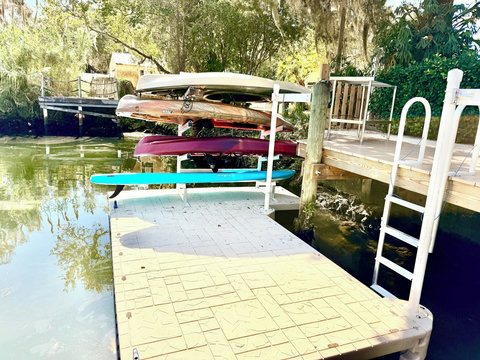 3 fishing kayaks, paddleboard and a youth kayak on a floating dog